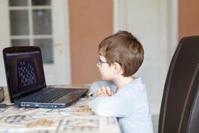 Ung kille spelar schack online